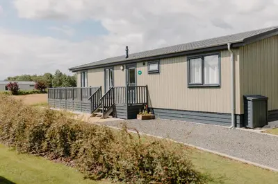 a manufactured home with a porch and a house at Linwater Caravan Park - Luxury Lodges and Static Caravans near Edinburgh in Newbridge