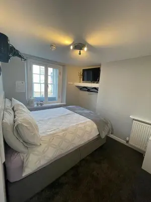 a bedroom with a large bed in a room at Black Bull with Rooms upper in Cumbernauld