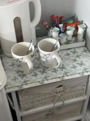 two cups sitting on a table with a counter at Black Bull with Rooms upper in Cumbernauld