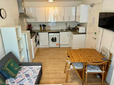 a kitchen with a wooden table and a kitchen with a washing machine at Edinburgh Central Apartment in Edinburgh