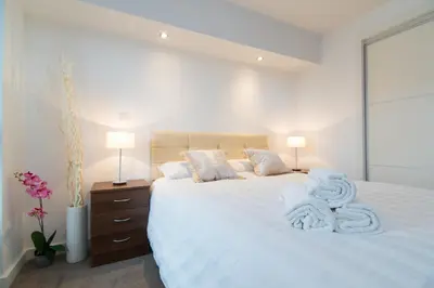 a bedroom with a white bed with towels on it at Mitchell Street Glasgow Apartment in Glasgow