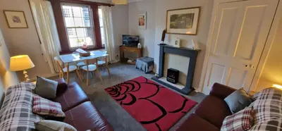 a living room with a couch and a fireplace at Morris Terrace Apartment in Stirling