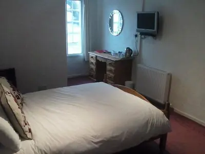 a bedroom with a bed and a desk and a television at Lochgair Hotel in Lochgair