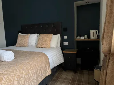 a bedroom with a bed and a blue wall at Sandvilla Guesthouse in Oban