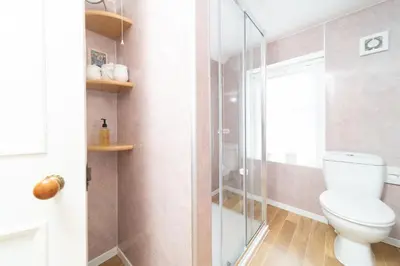 a bathroom with a toilet and a glass shower at The Foresters Guest House in Inverkip