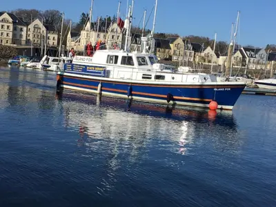 a blue and white boat sitting in the water at The Foresters Guest House in Inverkip
