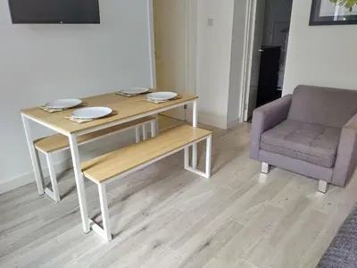 a table and a chair in a room at Glasgow Hampden Garden Flat in Glasgow