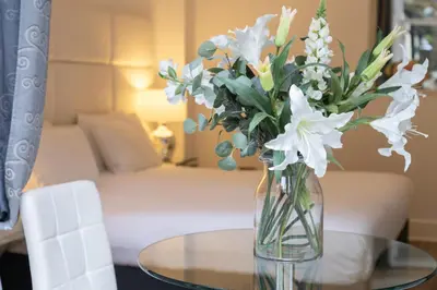 a vase of flowers sitting on a glass table at Edinburgh Castle Apartments in Edinburgh