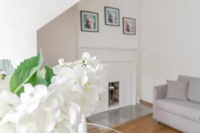 a living room with a fireplace and a vase with white flowers at Edinburgh Castle Apartments in Edinburgh