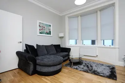 a living room with a black couch and a chair at Dreamhouse Apartments Glasgow St Vincent Street in Glasgow