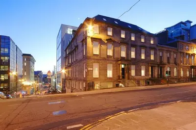 an old building on a city street at night at Dreamhouse Apartments Glasgow St Vincent Street in Glasgow