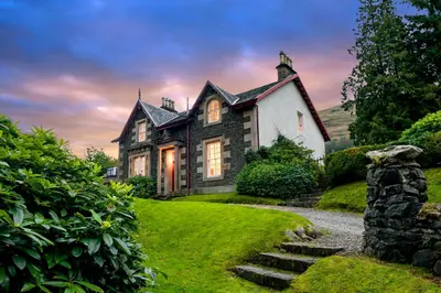 an old house on a hill with green grass at Mansefield House in Arrochar