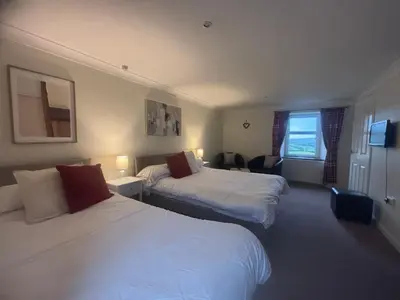 a hotel room with two beds and a window at Airds Farm Guest House in Castle Douglas