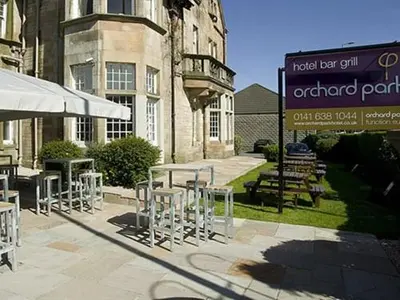 a group of tables and chairs in front of a building at The Orchard Park Hotel in Giffnock