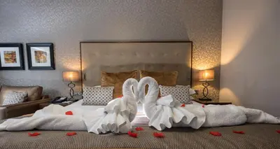 a bedroom with two swans made out of towels at Parklands Hotel & Country Club in Newton Mearns