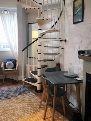 a dining room with a table and a spiral staircase at Heritage City - The Auld Pottery in Edinburgh