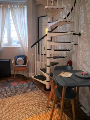 a dining room with a table and a spiral staircase at Heritage City - The Auld Pottery in Edinburgh