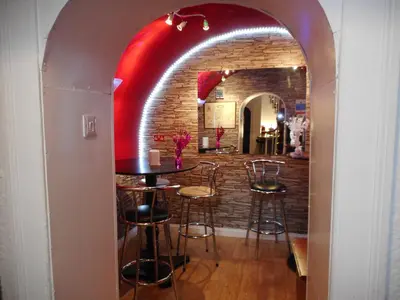 an archway in a restaurant with a table and stools at Telford Manor House in Beattock