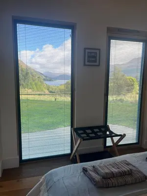 a bedroom with a large window with a view at Ceo Mara Croft b&b & 2 luxury Cabins in Taynuilt
