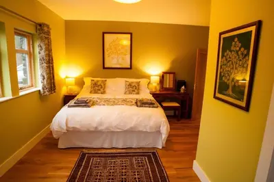 a bedroom with a large bed with yellow walls at Ceo Mara Croft b&b & 2 luxury Cabins in Taynuilt