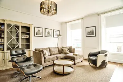 a living room with a couch and chairs at JOIVY Luxury Flats on George Street in Edinburgh