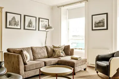 a living room with a couch and a table at JOIVY Luxury Flats on George Street in Edinburgh