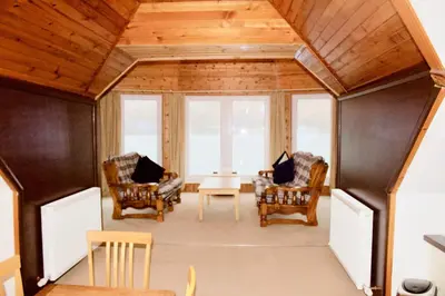 a living room with two chairs and a table at The Boathouse in Glencoe