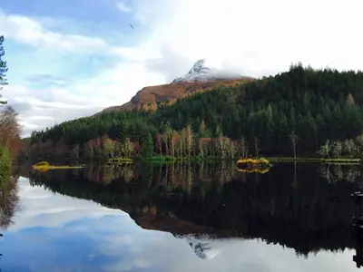a mountain reflection in a lake with a mountain in the background at Park View in Ballachulish