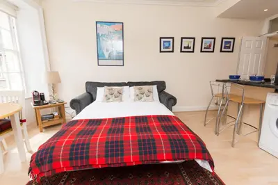a red and black plaid bed in a room at Luxury New Town 1 Bed Apartment in Edinburgh