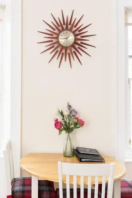 a dining room table with a clock on the wall at Luxury New Town 1 Bed Apartment in Edinburgh