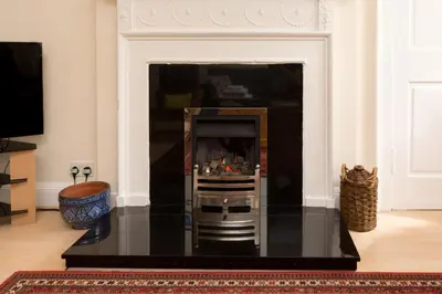 a living room with a fireplace with a table at Luxury New Town 1 Bed Apartment in Edinburgh