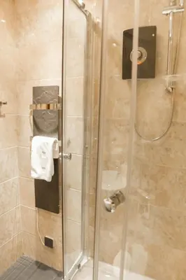 a shower with a glass door in a bathroom at Castle view&Grassmarket studio flat with Luxury bathroom in Edinburgh