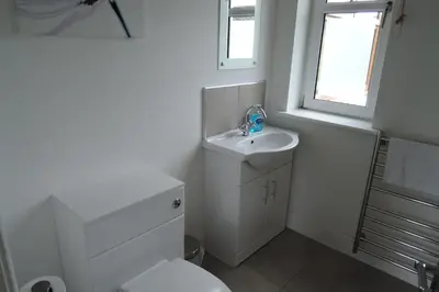 a bathroom with a sink and a toilet and a window at Tigh Beg Croft in Lerags