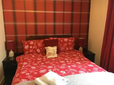 a red bed in a room with a red wall at The Guest Wing in Rothesay