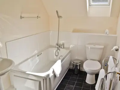 a bathroom with a tub and a toilet and a sink at Hearthstanes Steading in Polmood