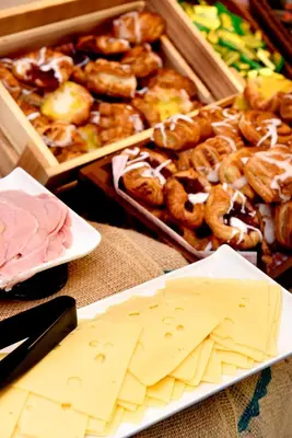a table with a tray of pastries and a plate of cheese at Juniper Court in Stirling