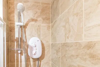 a shower with a white shower head in a bathroom at Mycosyapartments54 in Paisley