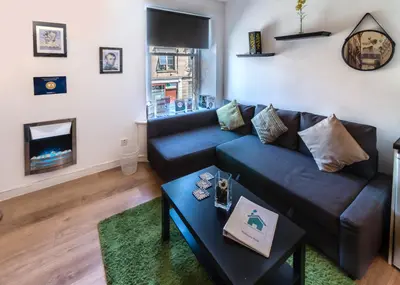 a living room with a couch and a fireplace at Mycosyapartments54 in Paisley