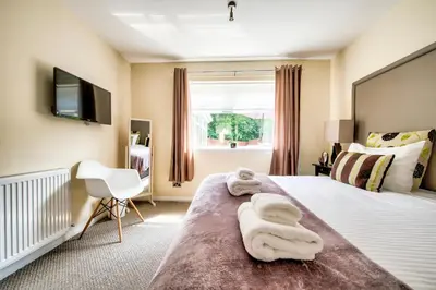 a bedroom with a large bed with towels on it at No.17 Serviced Apartment in Glasgow