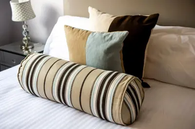 a pile of pillows sitting on a bed at No.17 Serviced Apartment in Glasgow