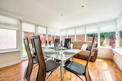 a dining room with a table and chairs and a couch at No.17 Serviced Apartment in Glasgow