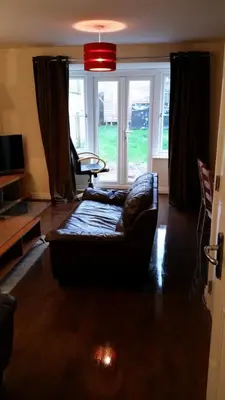 a living room with a couch in front of a window at Livingston Ideal commuter House in Livingston