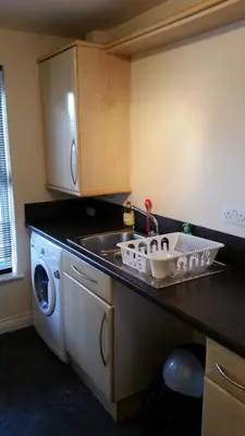 a kitchen with a sink and a washing machine at Livingston Ideal commuter House in Livingston