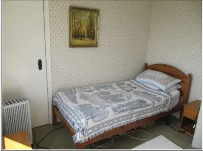 a bedroom with a bed with a picture on the wall at Braeside Craighouse Jura in Craighouse