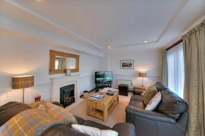 a living room with two couches and a television at Katie's Flat in Oban