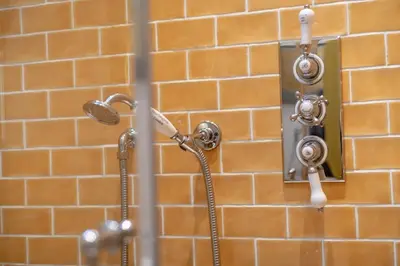 a bathroom with a shower and a shower head at Gardener's Cottage in Crieff