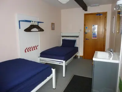 a hospital room with two beds and a door at Port Charlotte Youth Hostel in Port Charlotte