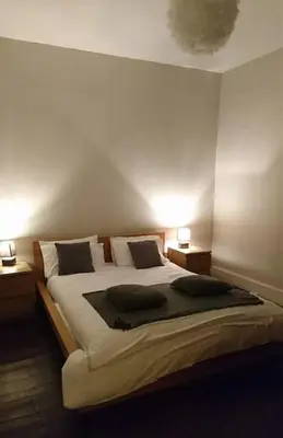 a bedroom with a large bed with two night stands at The Haven Cottage in Slamannan