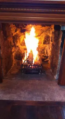 a fireplace with a fire in it at The Haven Cottage in Slamannan