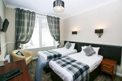 a hotel room with two beds and a window at Kelvingrove Hotel - Sauchiehall St in Glasgow